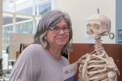 Melanie Gilbert poses with a skeleton.