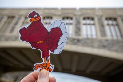 A picture of the HokieBird held up in front of Torgersen Bridge on the Virginia Tech campus.