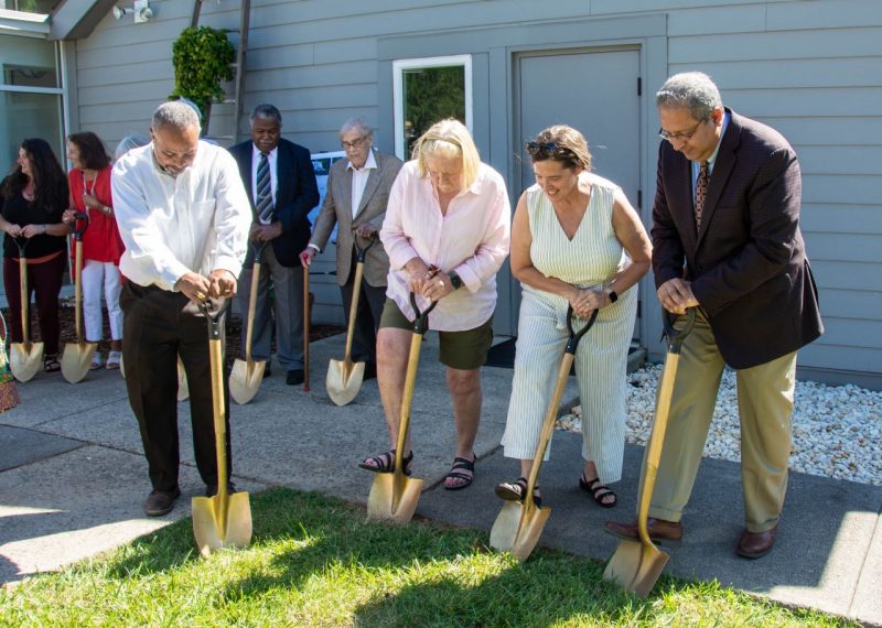 Four people dig golden shovels into the lawn at the Reynolds Homestead.