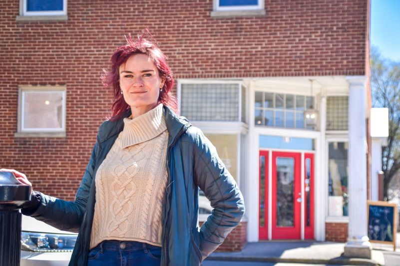 Picture of Joanie Willett standing in front of New River Art & Fiber, a store on Blacksburg's South Main Street.