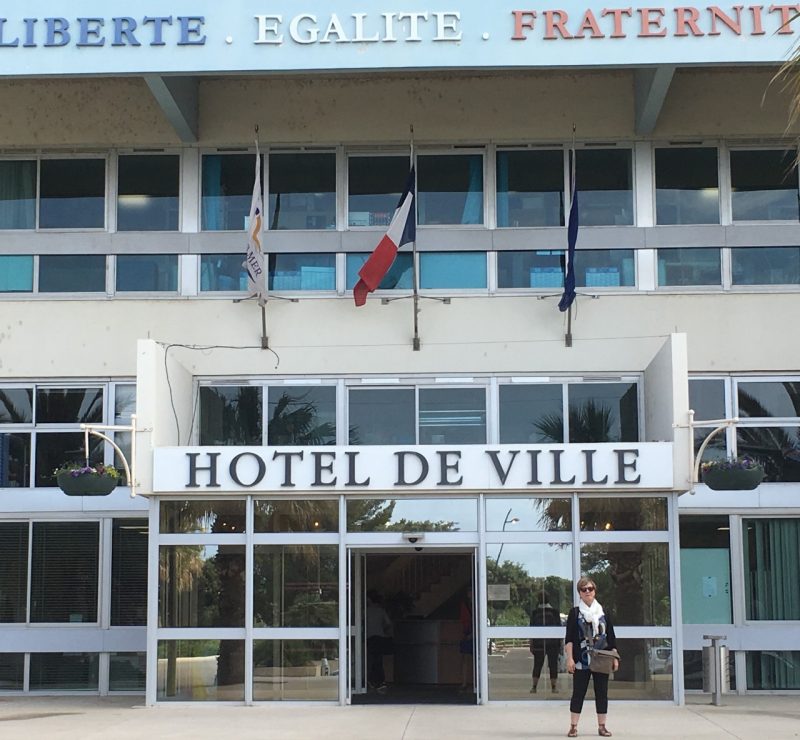 Barbara Allen stands in front of a large municipal building. 