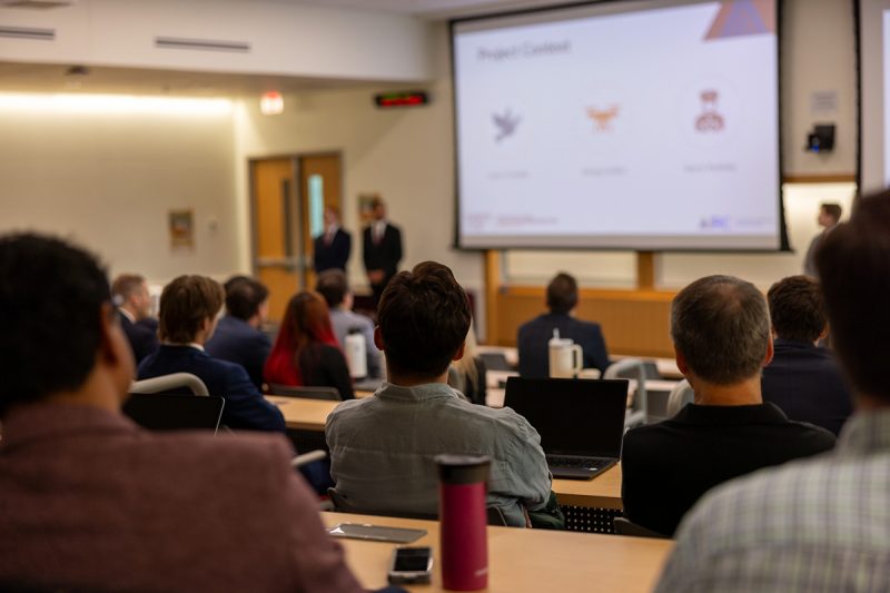 Attendees watch as students from the MSBA-BA program give their capstone presentation.