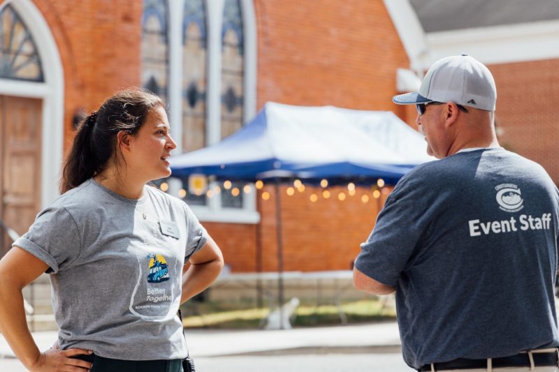 53_20240914_UtProsim_ElliTravis_CF_8075.jpg Elli speaks to a Town of Christiansburg employee who is also event staff for the food truck rodeo while standing in the middle of downtown.