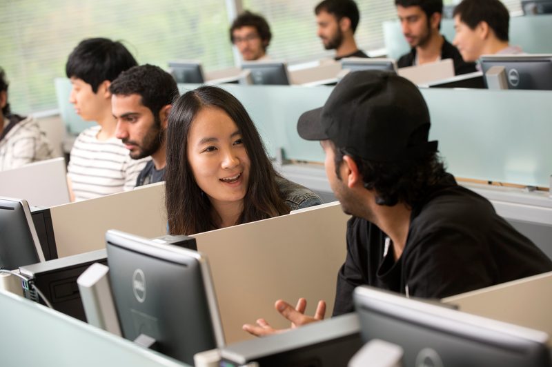 Students talking to one another in a computer lab