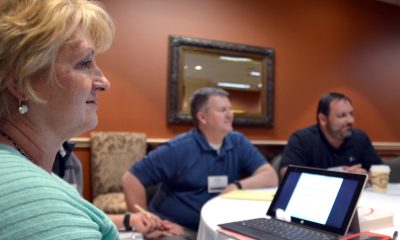 Three people sitting around a conference table