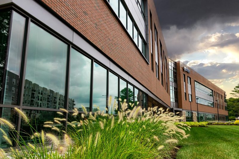 A modern brick office building with decorative grass.