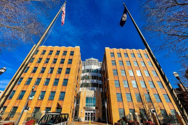 Tall brick building under deep blue skies and two flag poles.