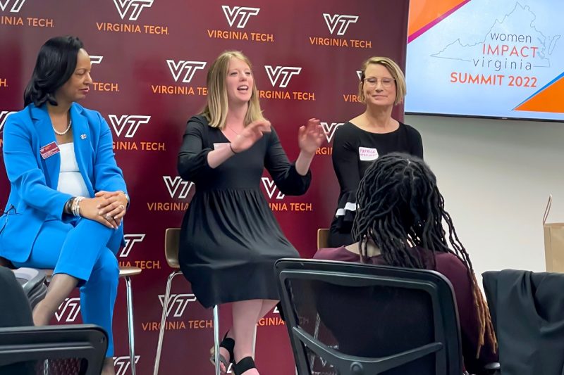 Panelists speak at the front of a room.