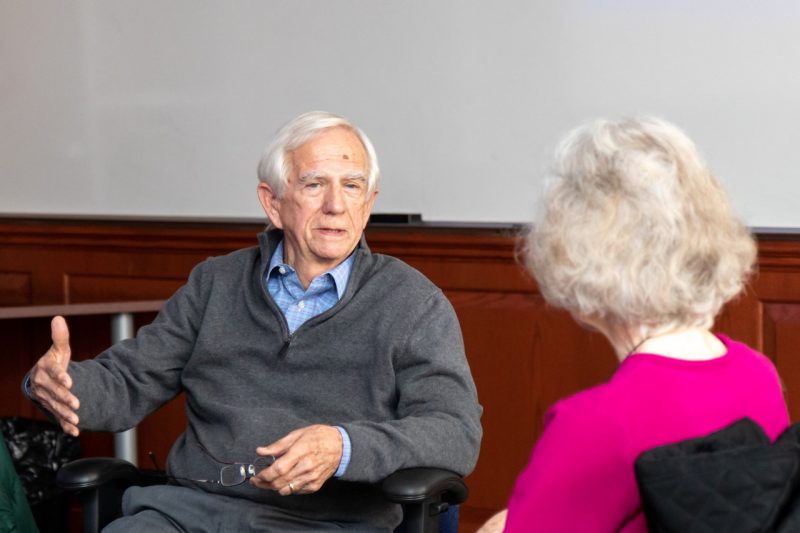 Lifelong Learning Institute A man sits in a desk chair talking to a woman.